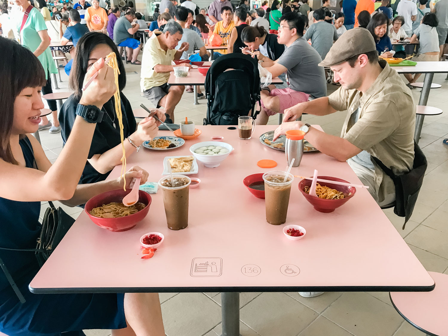 People sitting down eating at a communal table.