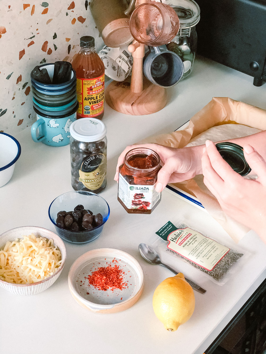 Medhā Lim holding a jar of sun-dried tomatoes.