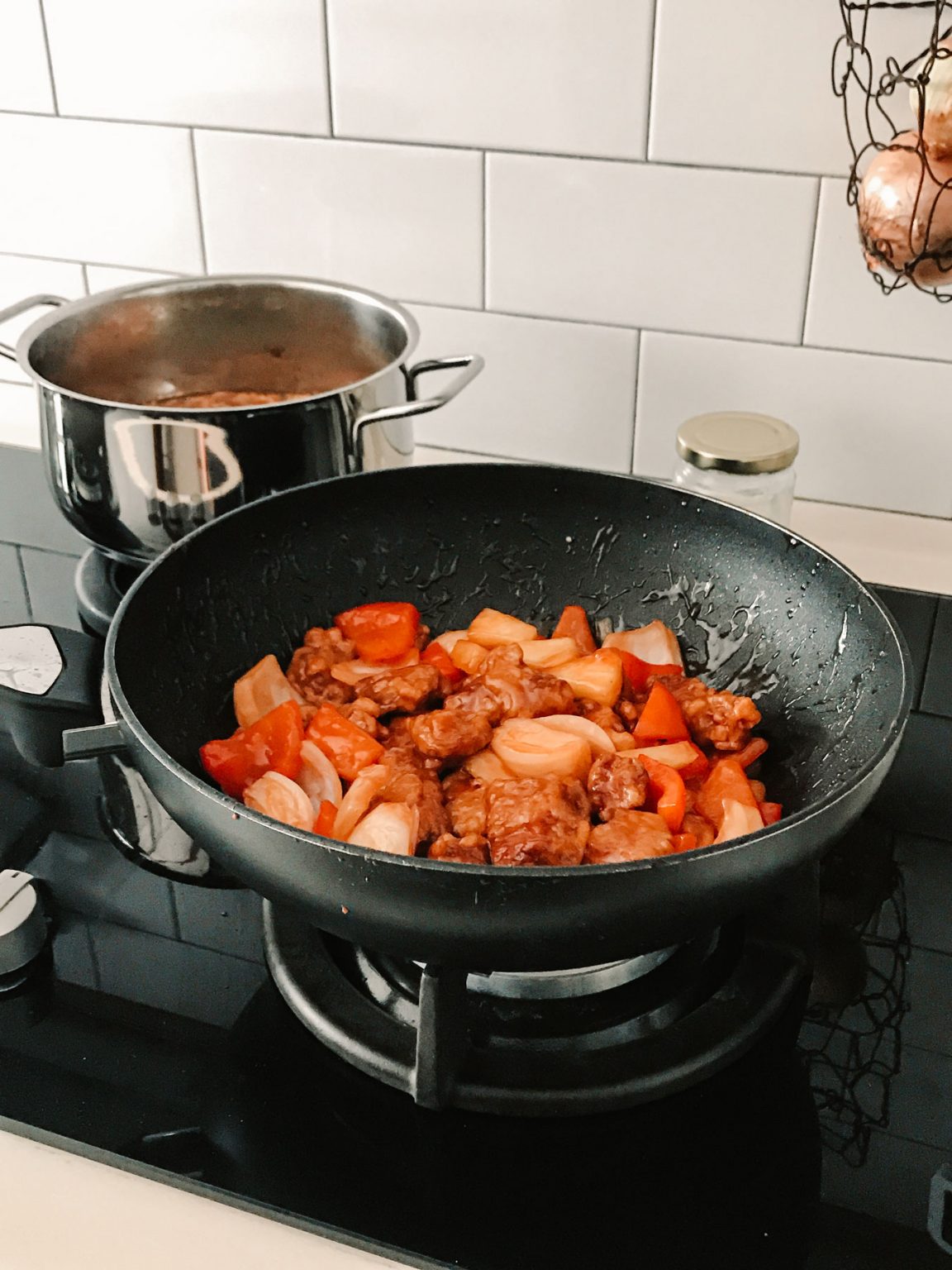Sweet and sour pork sautéing in a pan.