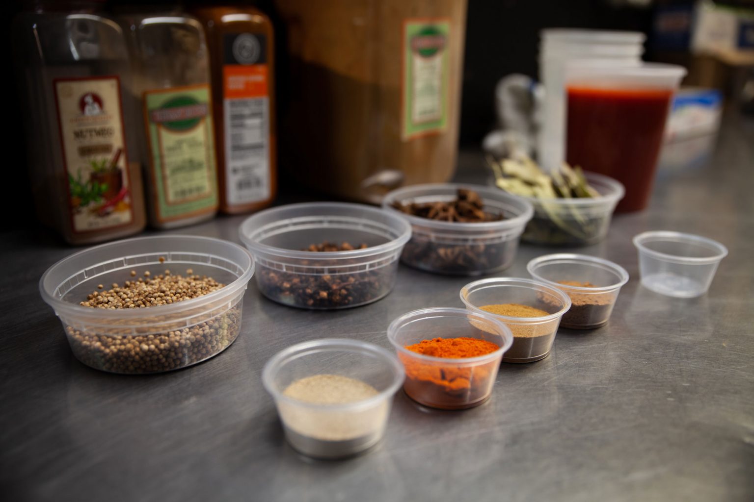 Small containers filled with a variety of spices and seasonings for snapper soup.