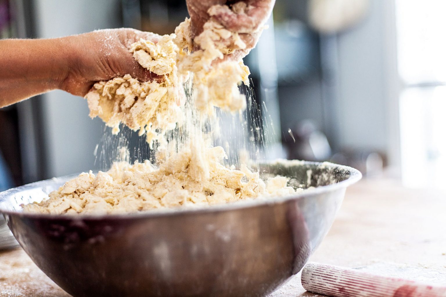Working dough into a bowl.