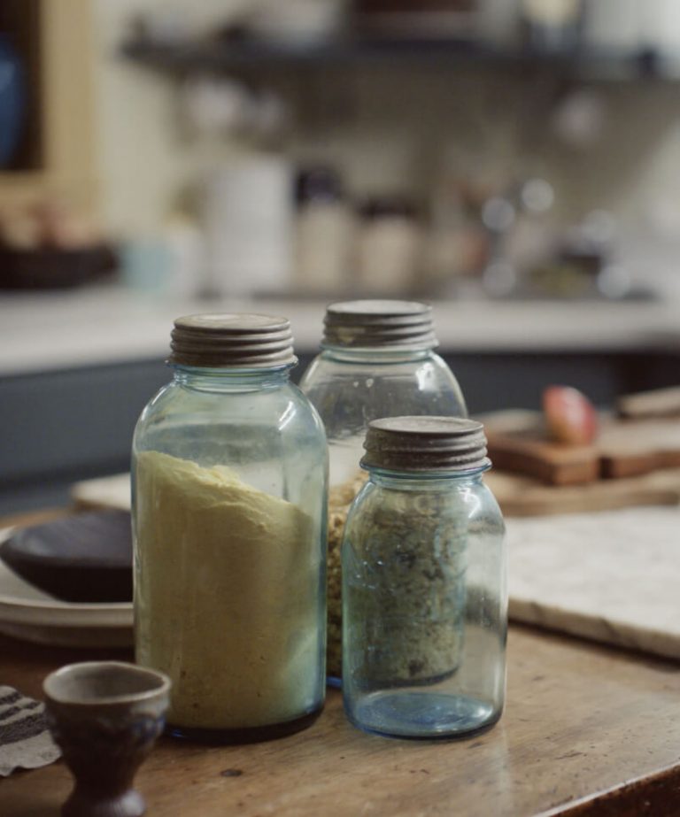 Three large, seasoning-filled jars resting on the kitchen counter.