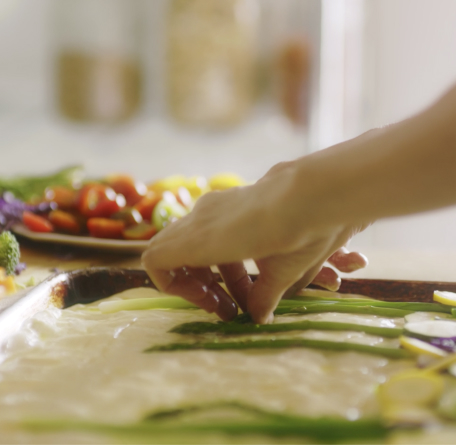 Loria Stern pressing vegetables into focaccia bread.