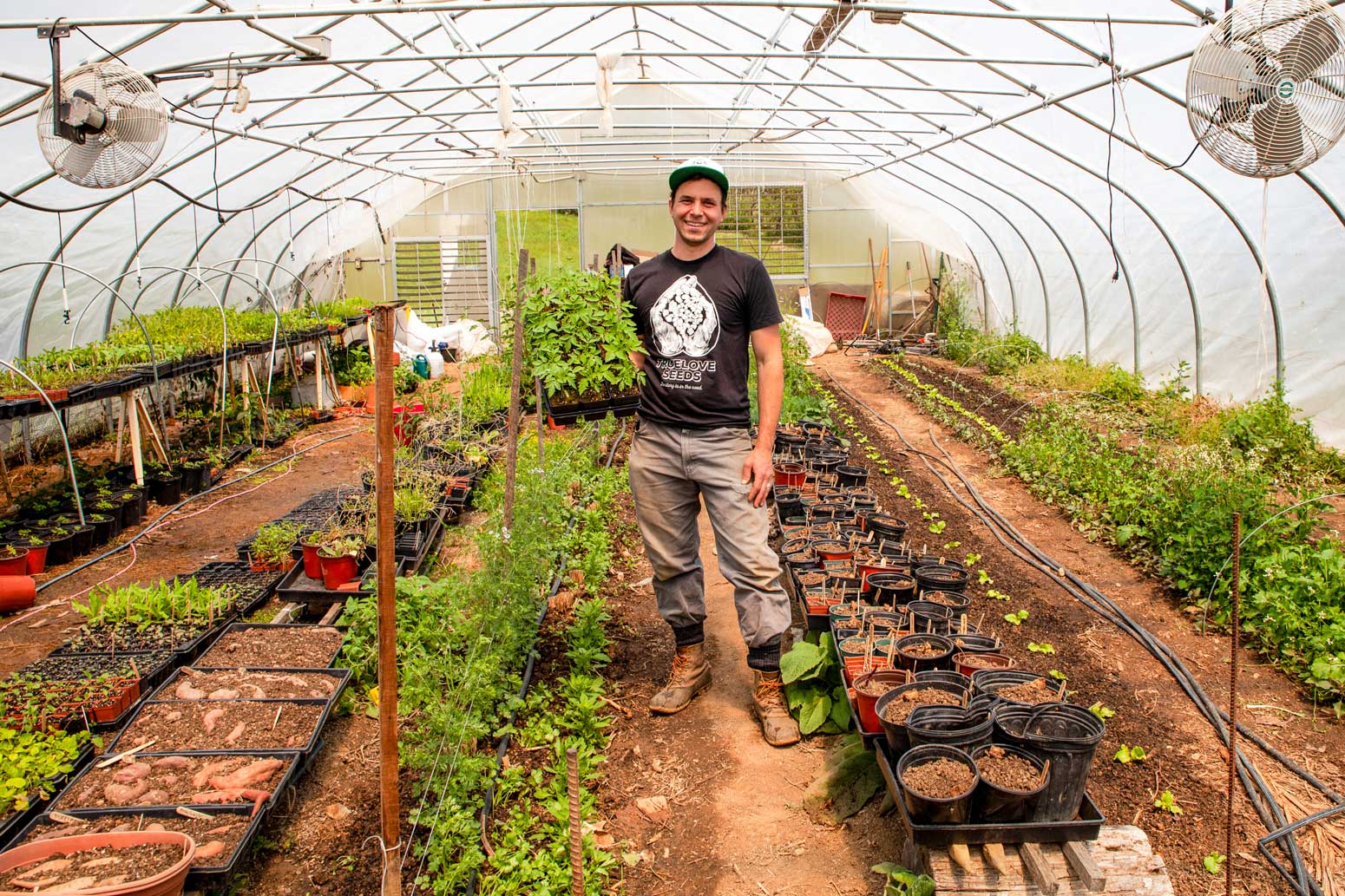 A gardener proudly showing off his nursery plants.