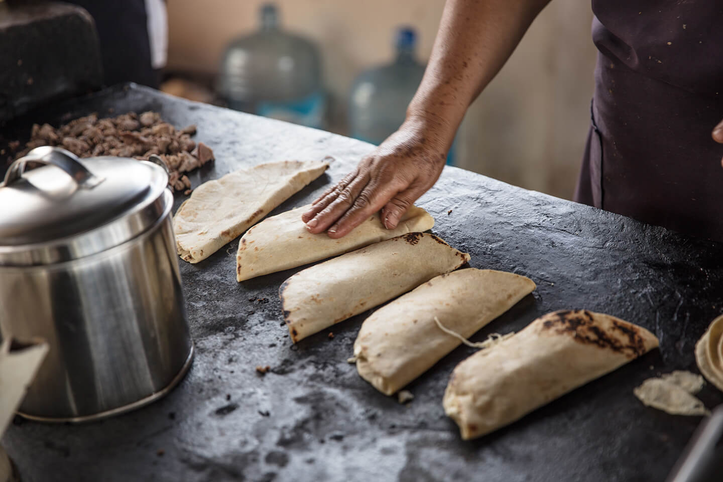 A person tending to folded flour tortillas.