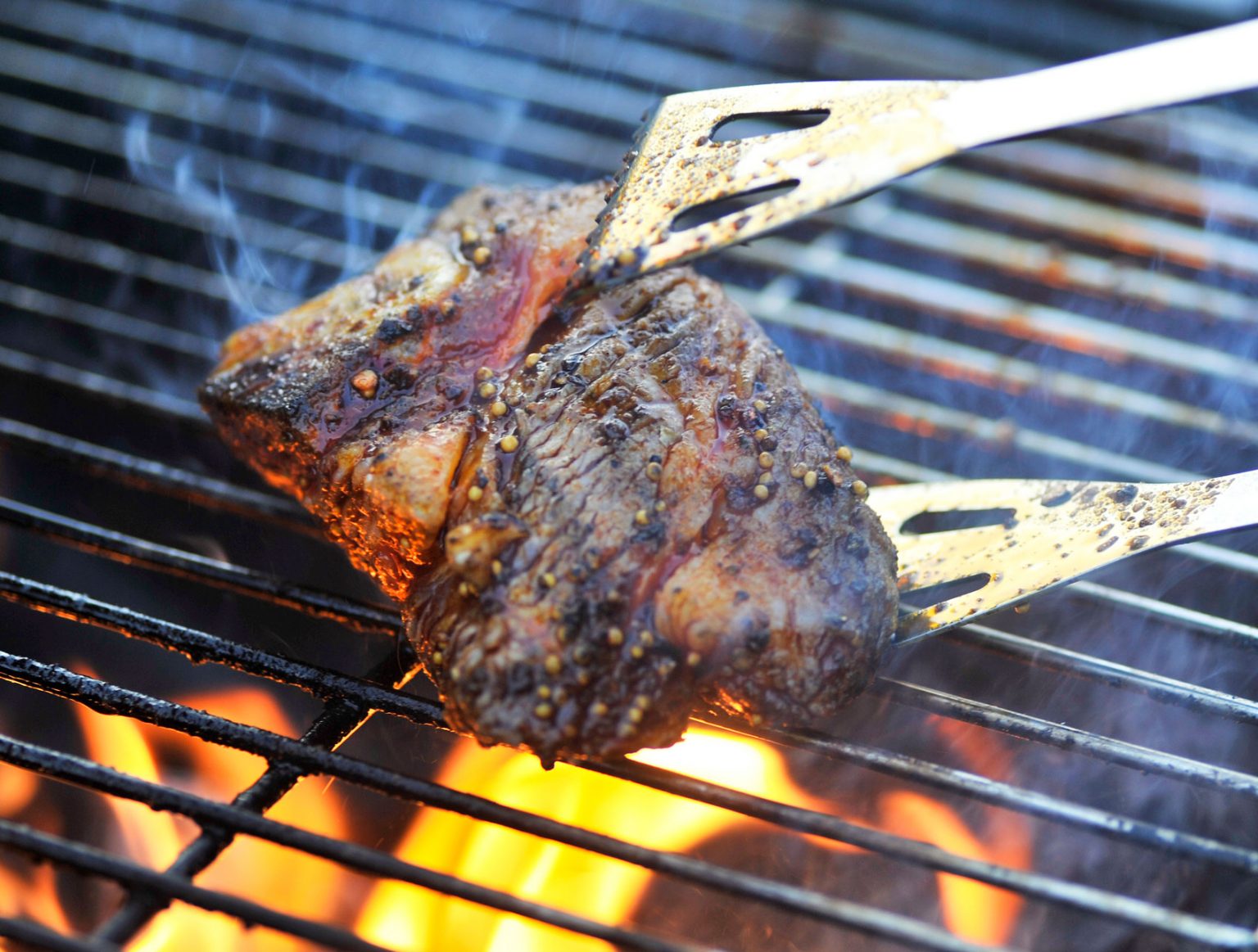 The iconic beef pit roasting on a charcoal grill.
