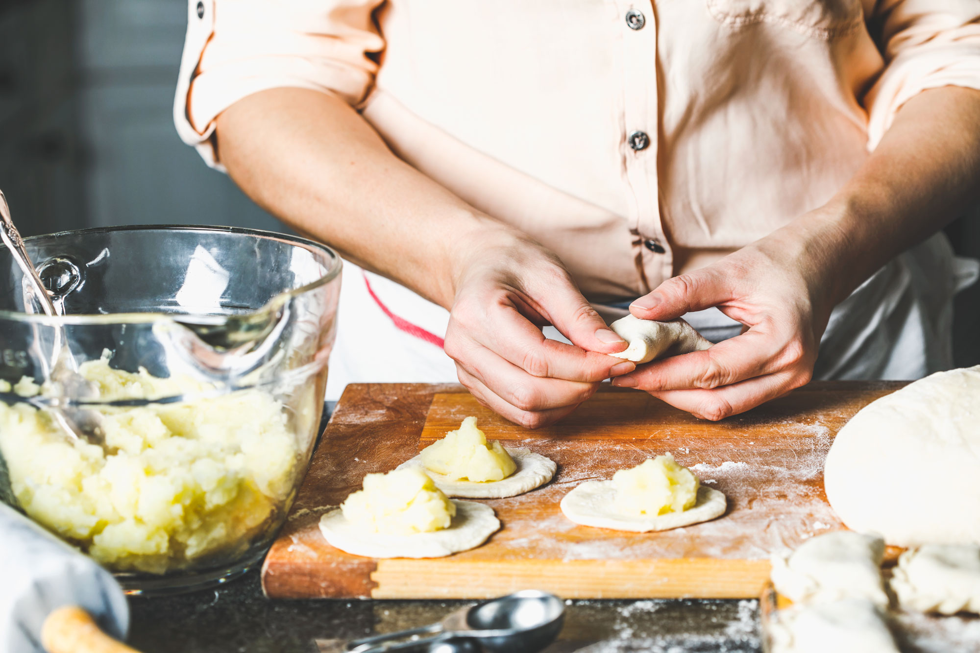 A person making fresh pierogies.