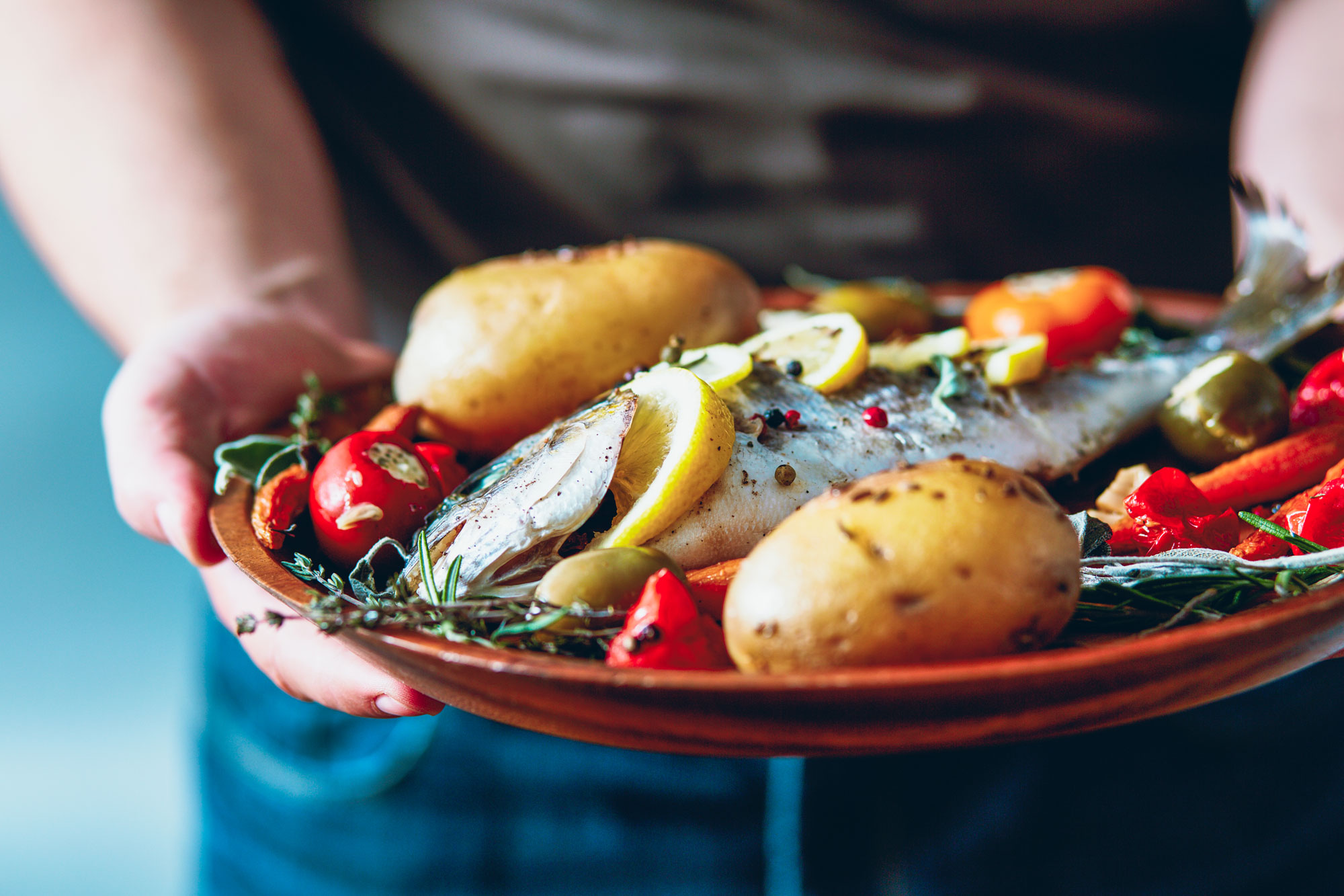 A plate of freshly cooked freshwater fish and whole potatoes.