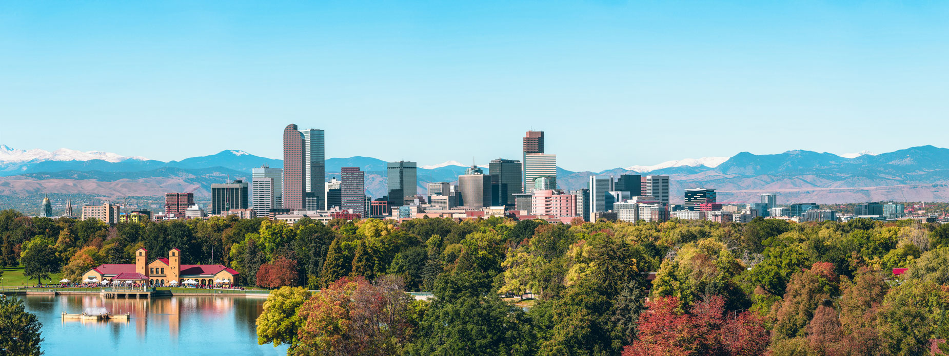 The city of Denver surrounded by picturesque mountains and colorful trees.