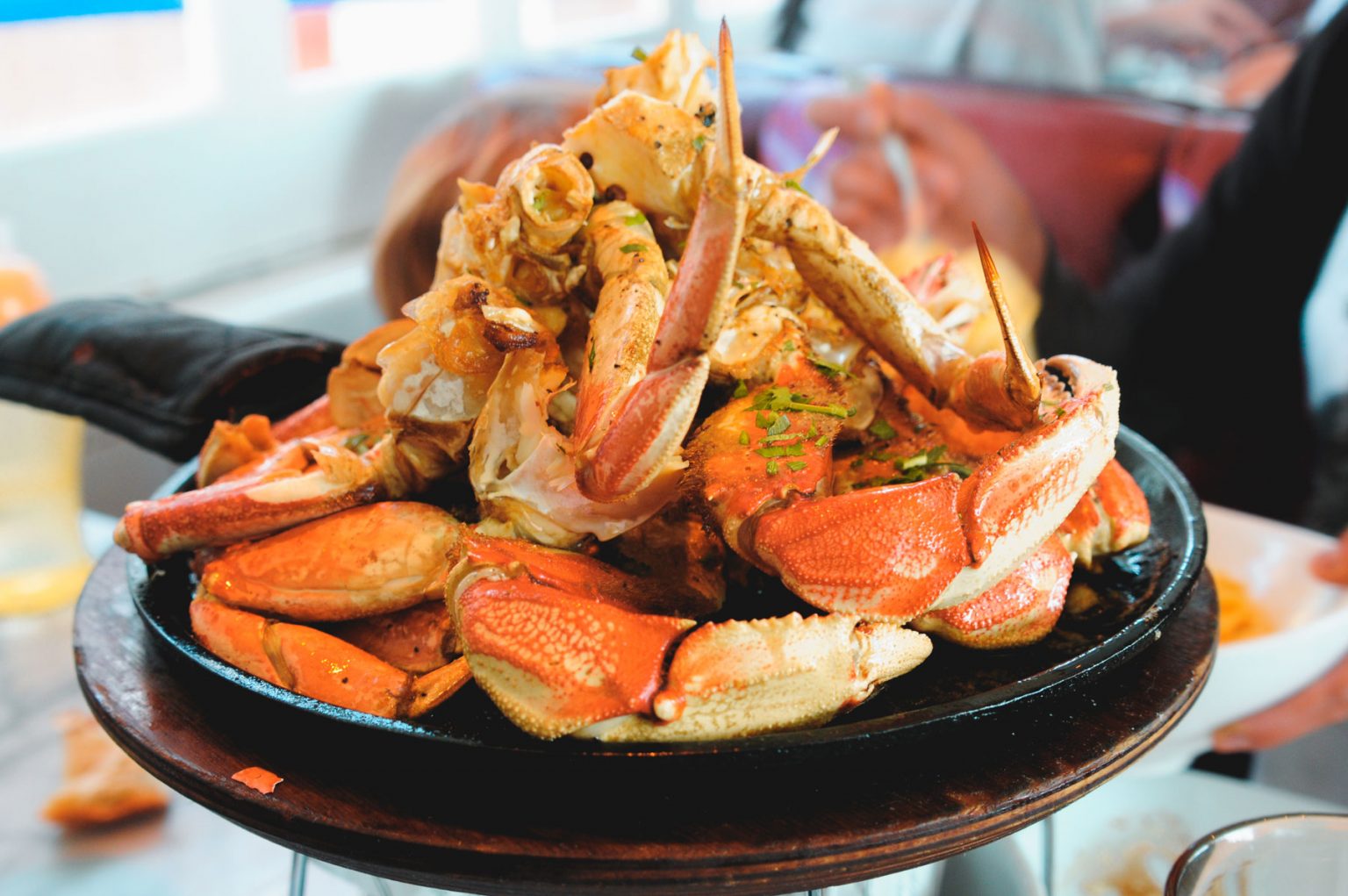 A cast iron skillet filled with steamed crab legs.
