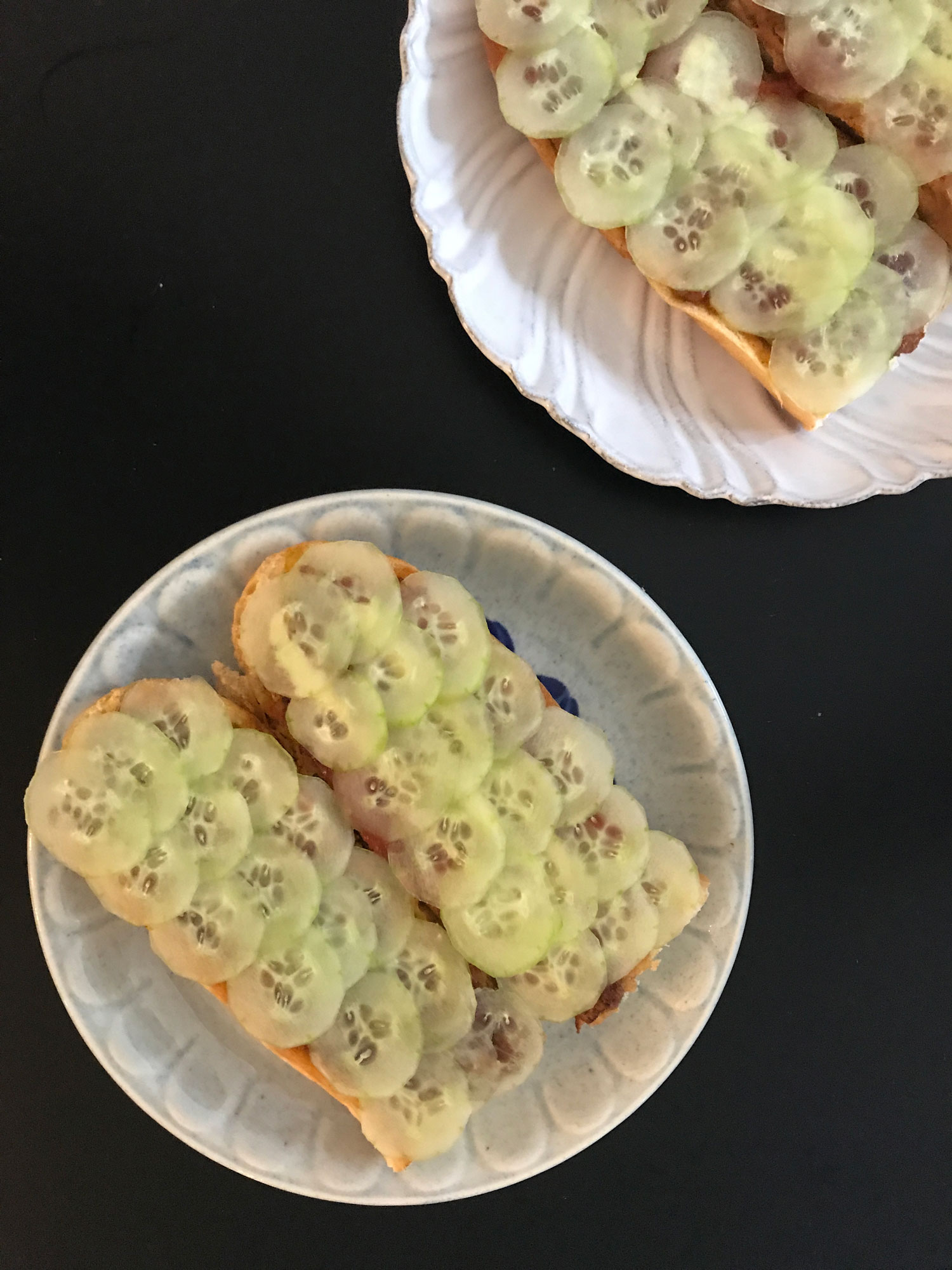 An open roti john filled with sliced cucumber.