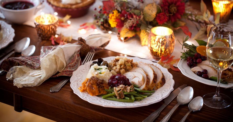 A festive table with dinner plate filled with delicious eats.