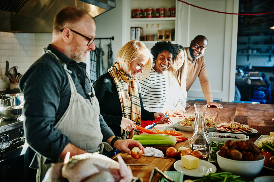 A family gathered in the kitchen preparing dinner.