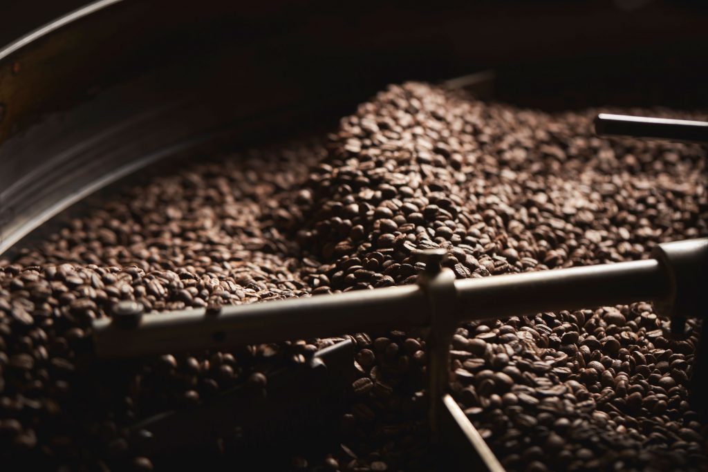A coffee roaster cooling and mixing a batch of freshly roasted coffee beans.
