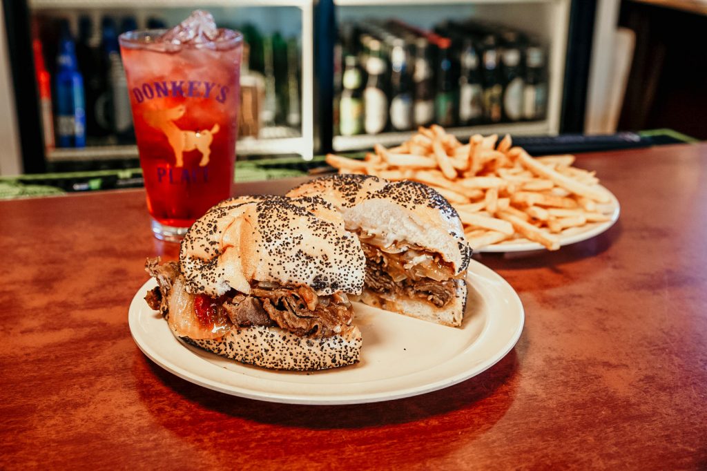 A plate of a Donkey's Place cheesesteak and french fries.