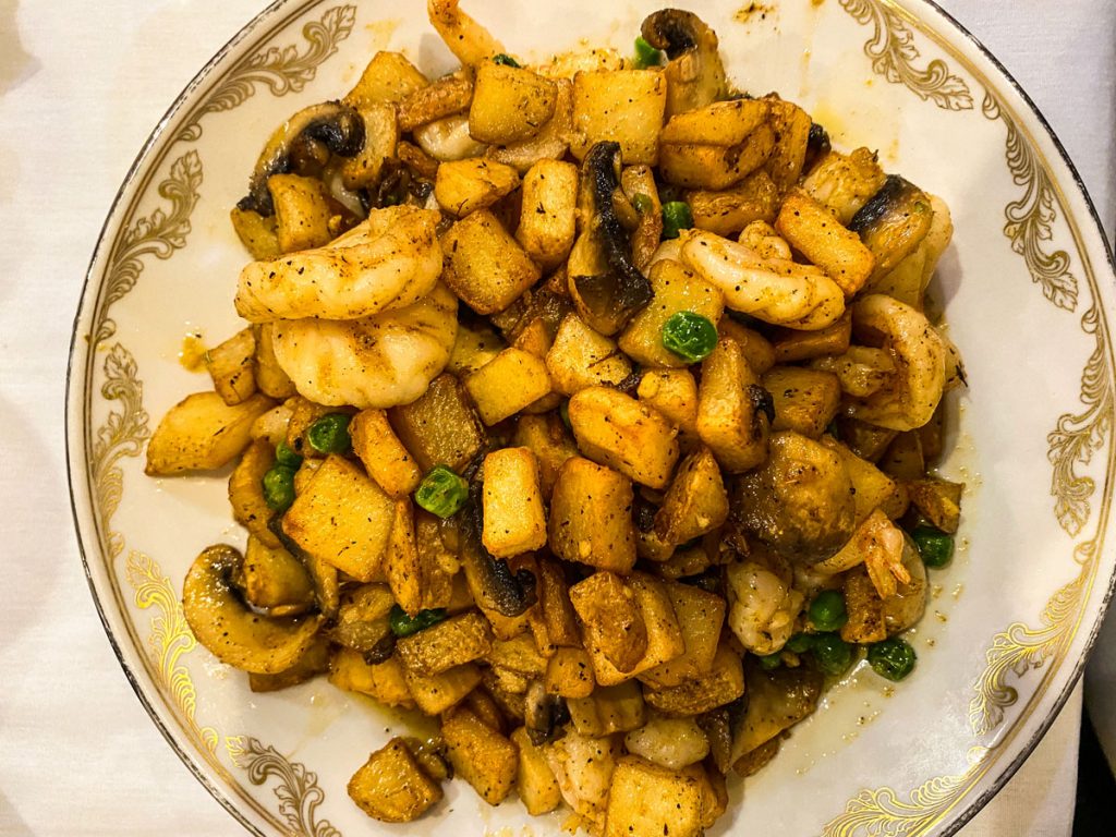 A delicious plate of potatoes, mushroom and shrimp.