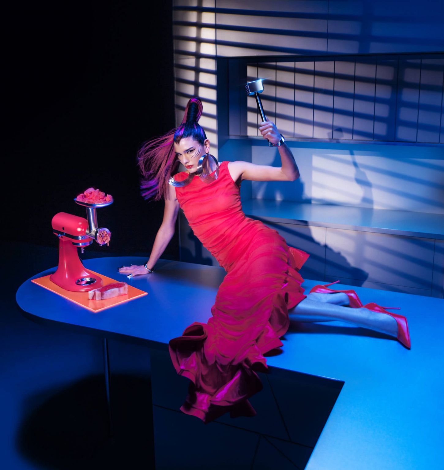 A model posing in a kitchen wearing Look Eight near the Artisan® Series Stand Mixer on an island using the meat grinder attachment.