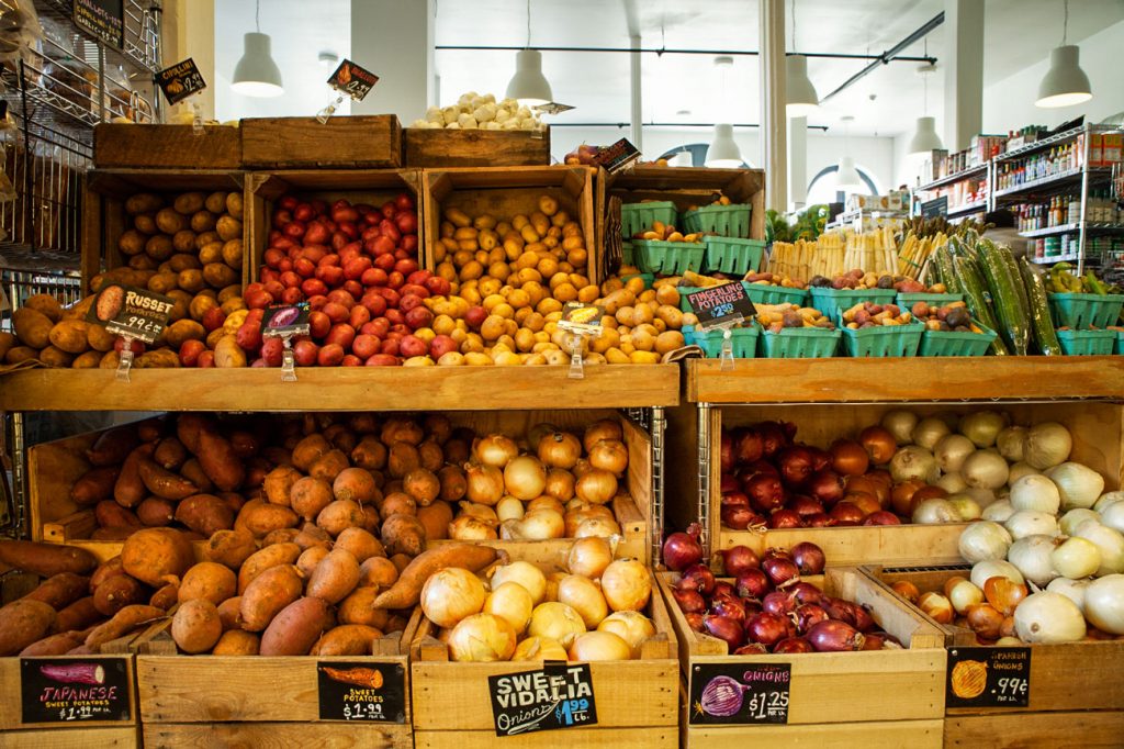 Potatoes and onions neatly displayed in wooden crates.