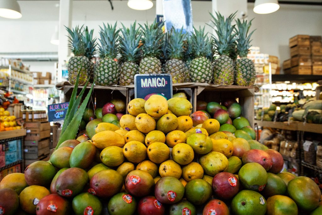 Piles of mangoes and pineapples out on display.