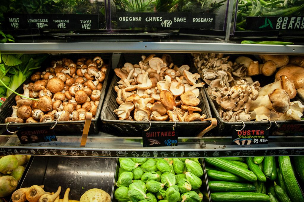 Several types of mushrooms displayed in woven baskets.