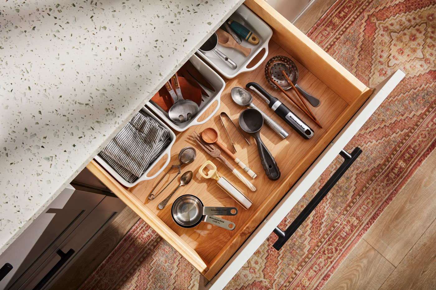 An open kitchen drawer filled with utensils neatly organized.