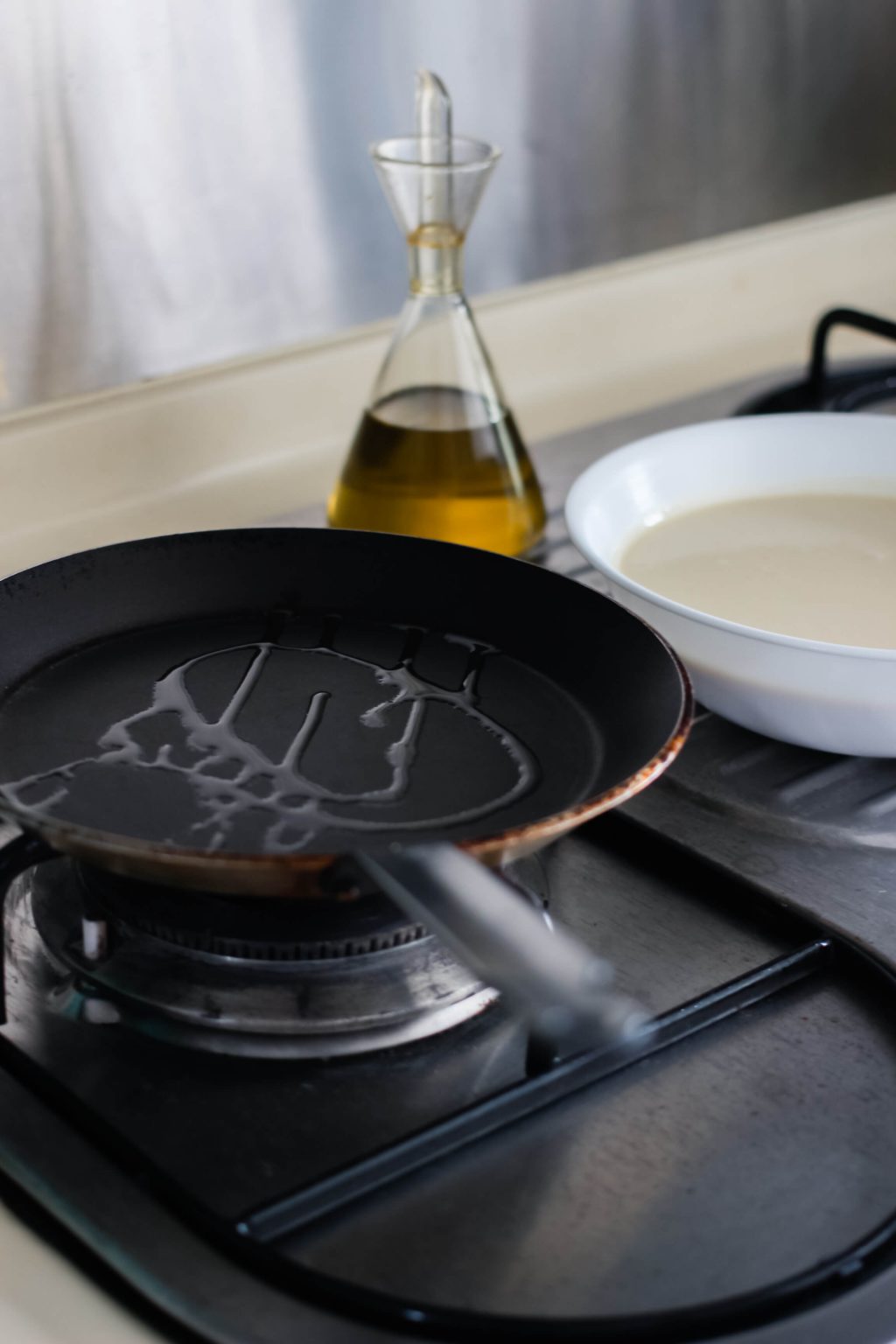 A small frying pan with a small drizzle of oil.