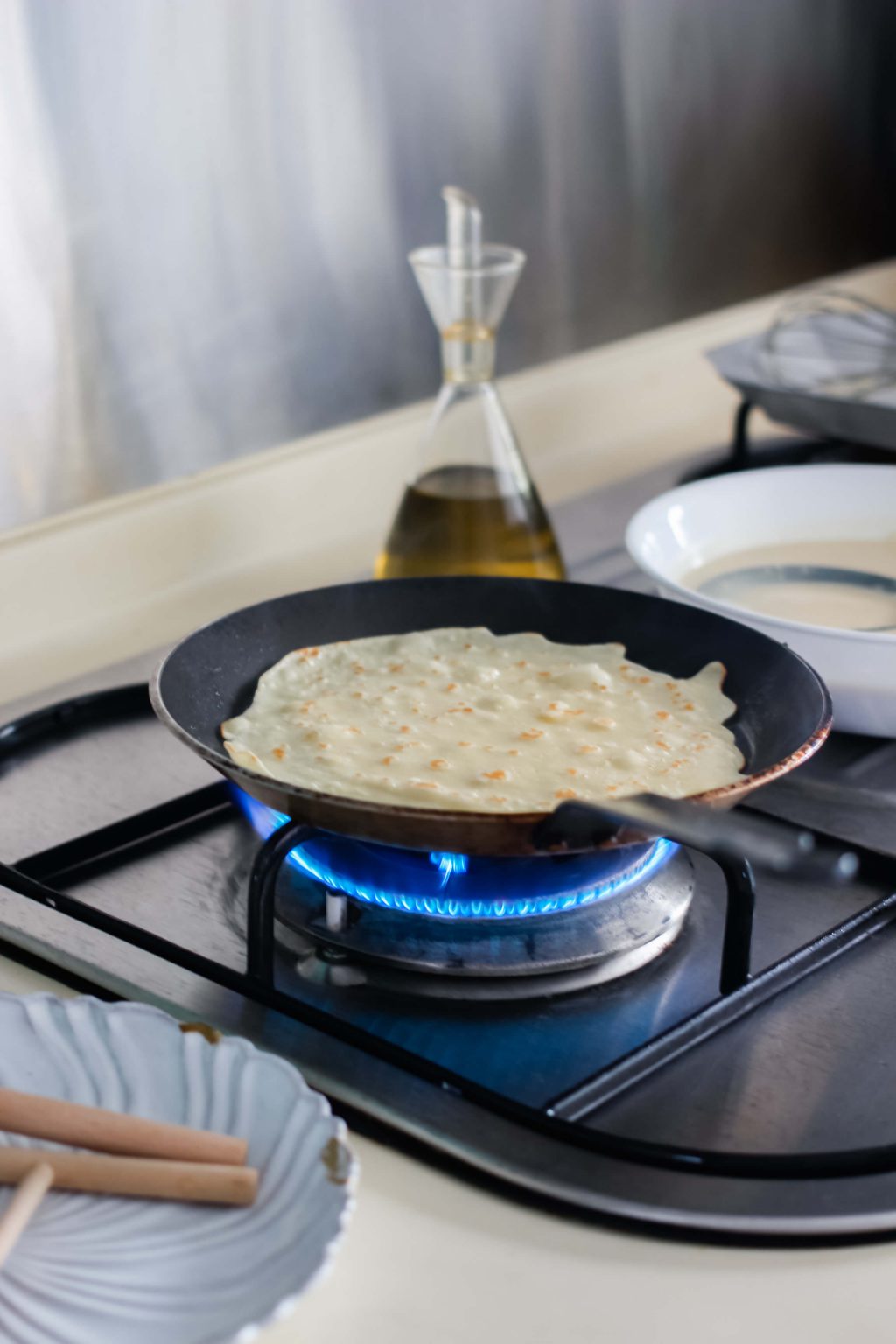 A pan cooking a crepe.