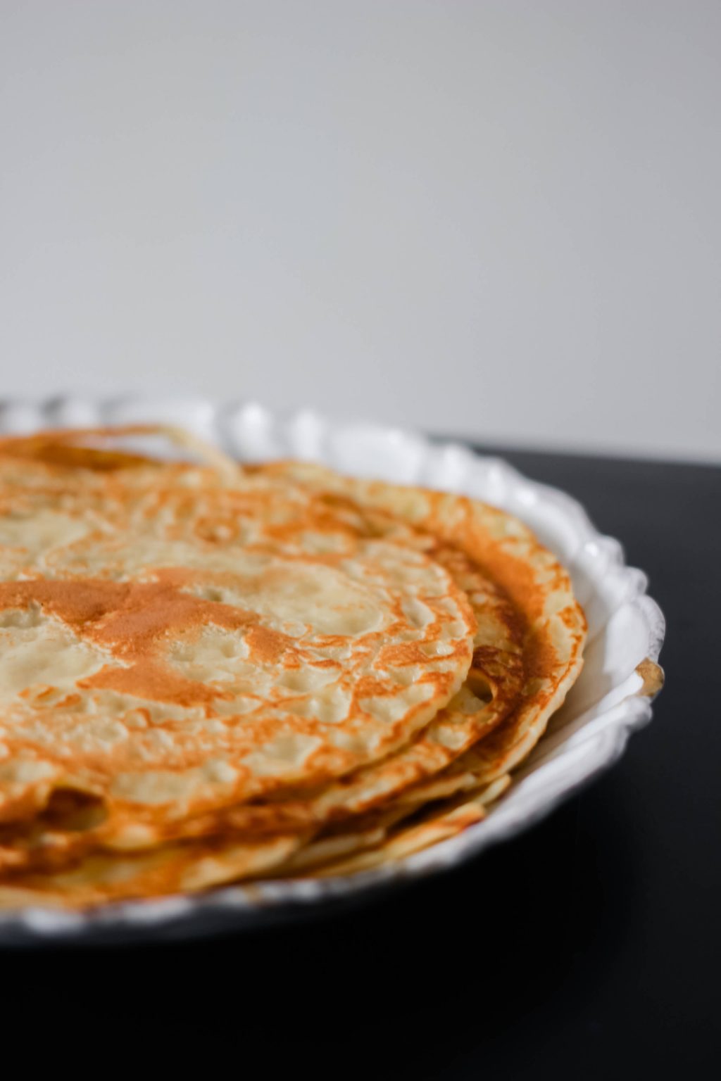 A plate filled with freshly made crepes.
