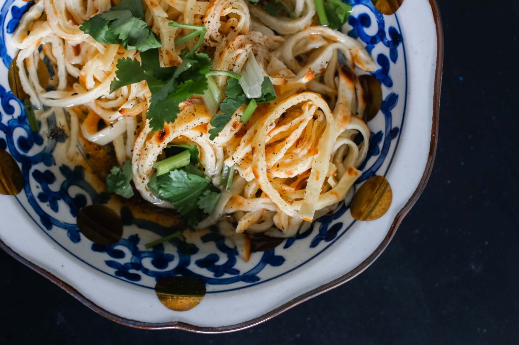A bowl of crepe noodles in broth.