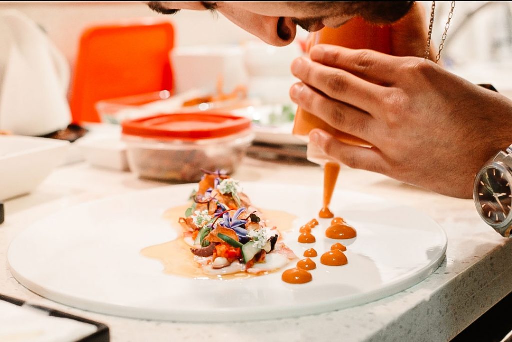 Behzad Jamshidi meticulously working over a dish.