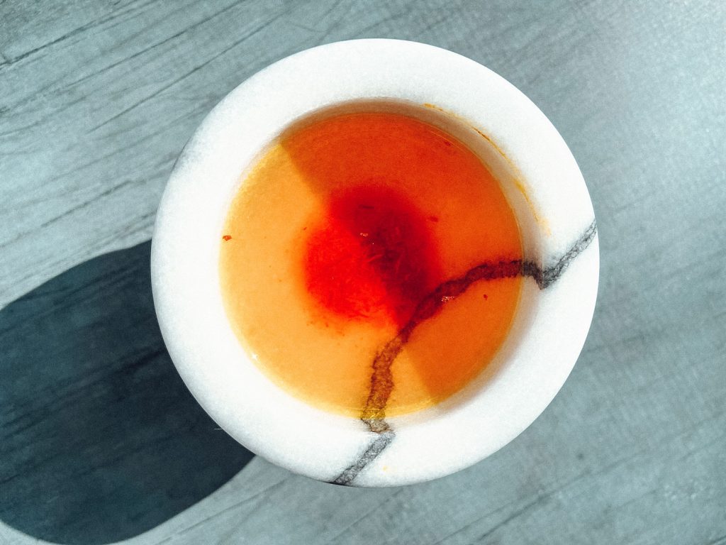 A small bowl of Gold Water: the liquid mixture of saffron, sugar and salt.