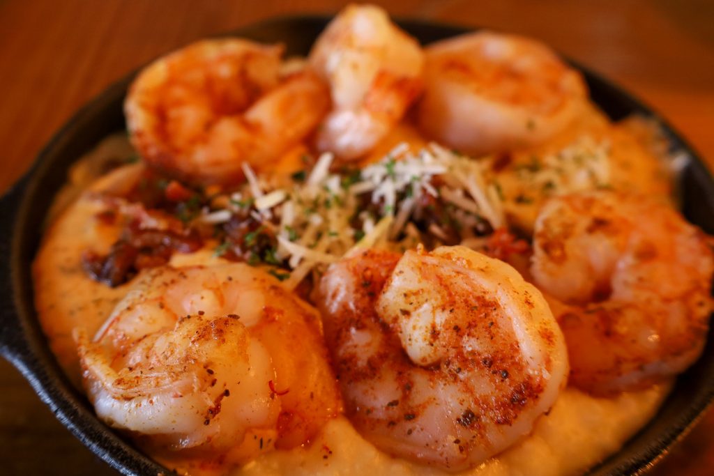 A cast iron skillet filled with shrimp and grits.