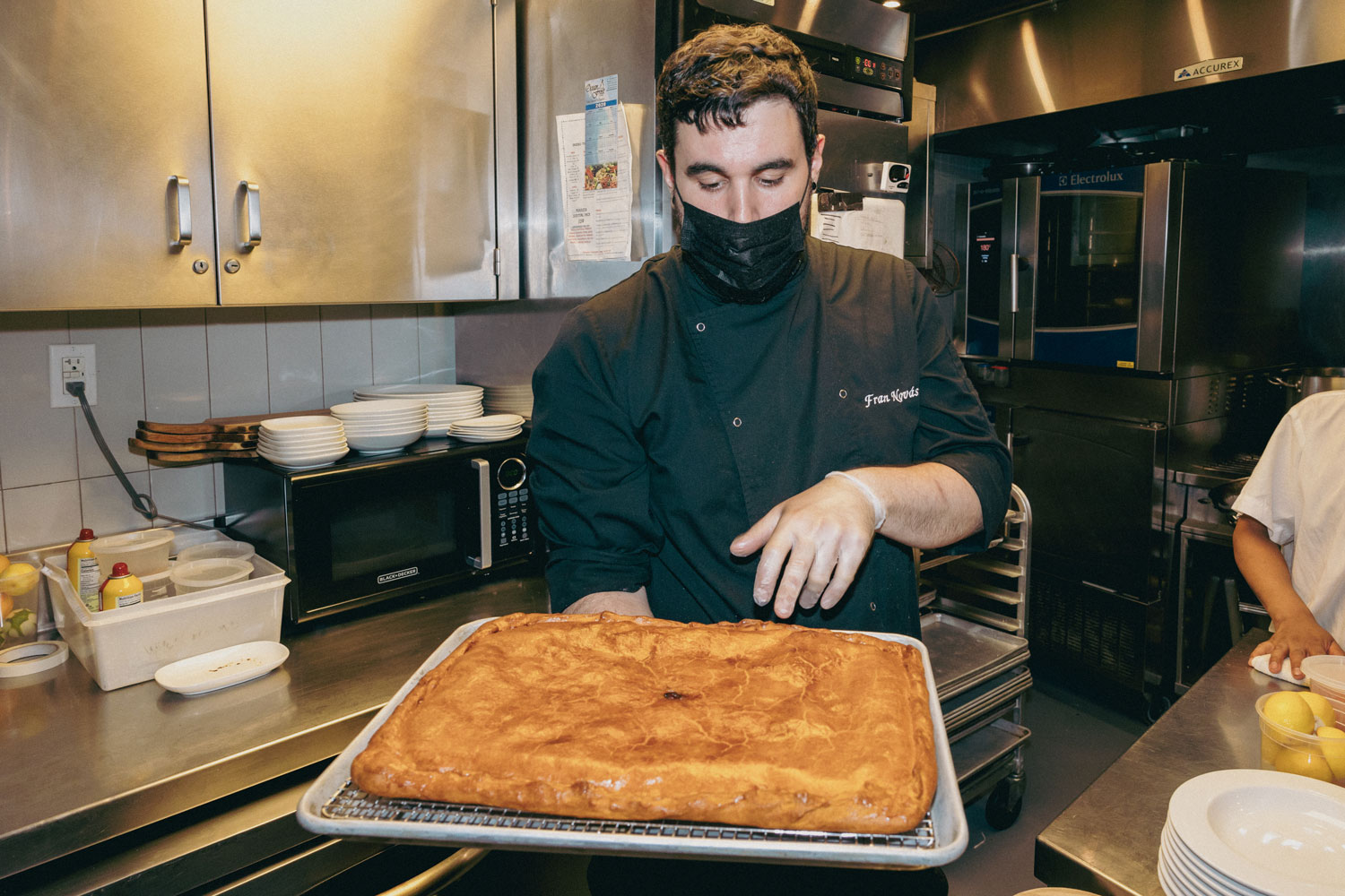 A chef holding a newly baked dish.
