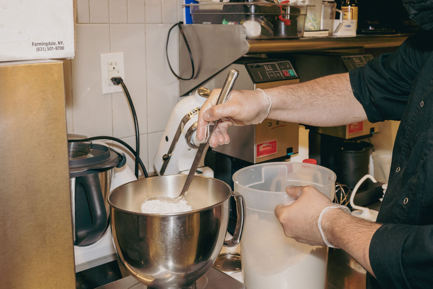 A person pouring flour into a bowl.