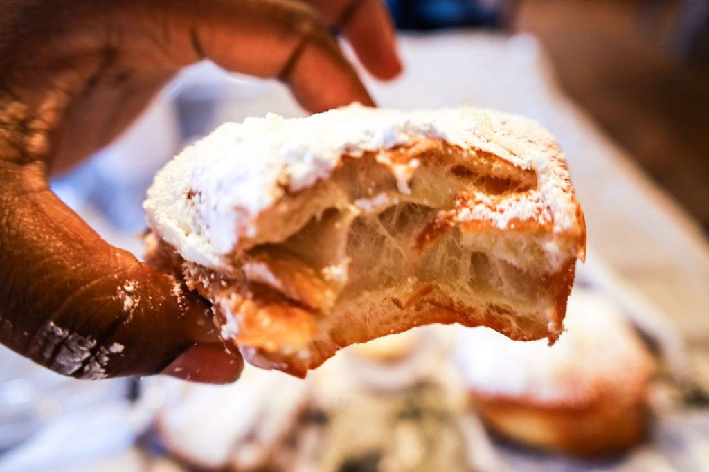 A person holding a beignets.