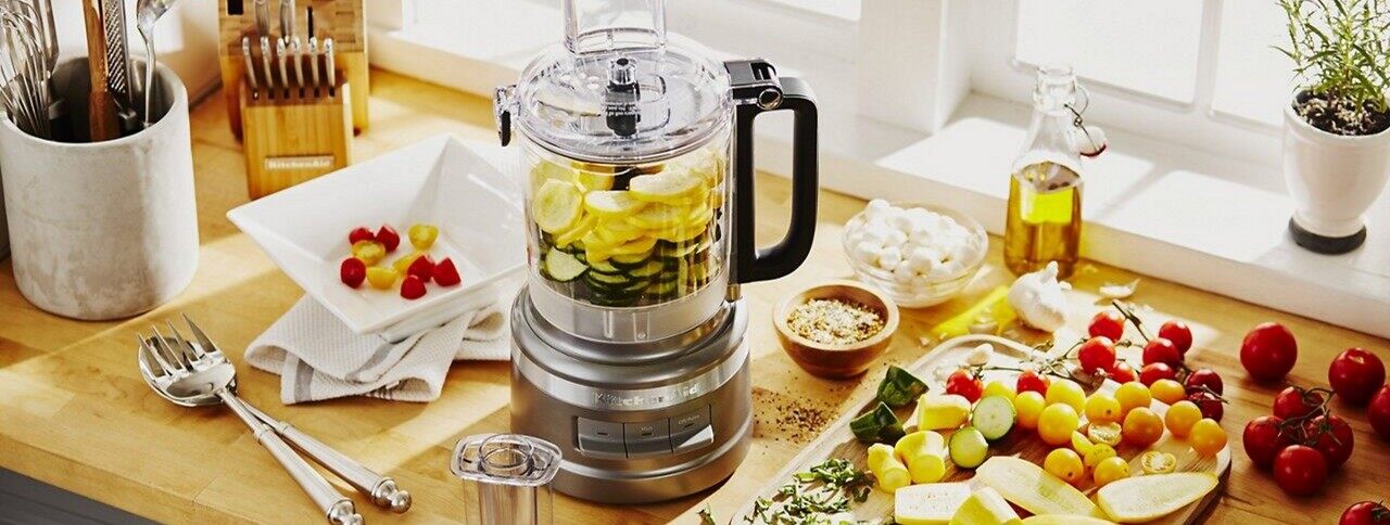 Silver food processor on counter with ingredients