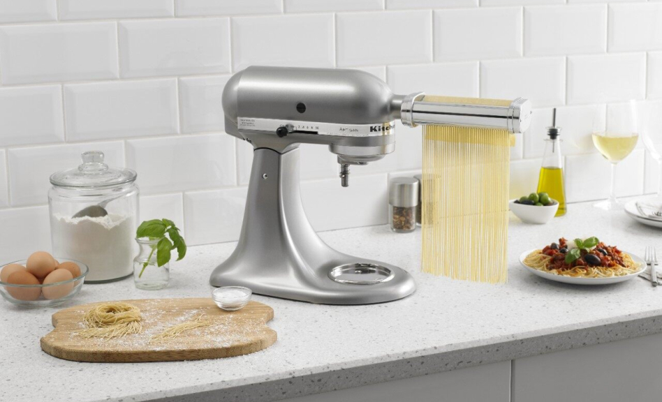 KitchenAid® stand mixer with pasta cutter attachment cutting pasta dough into thin strips. KitchenAid® stand mixer with pasta cutter attachment cutting pasta dough into thin strips.