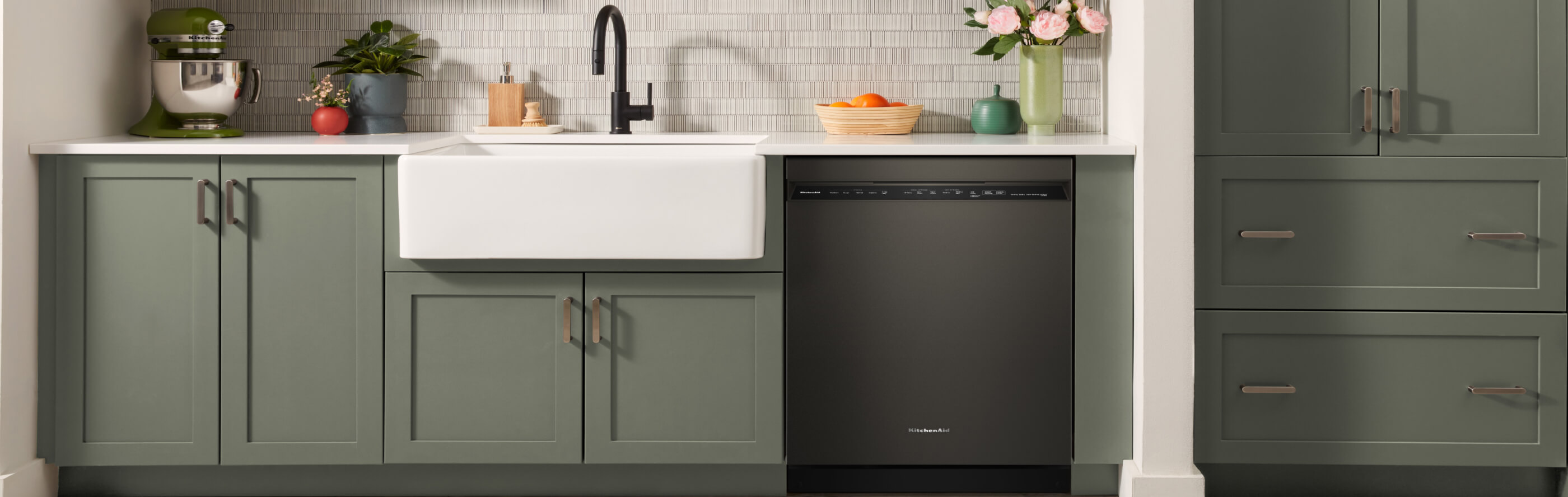 Black dishwasher in a green kitchen
