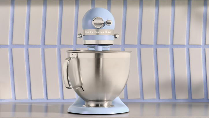 A front-facing Blue Salt stand mixer against a color-coordinating backsplash.
