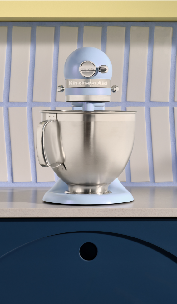 A Blue Salt stand mixer against a coordinating backsplash.