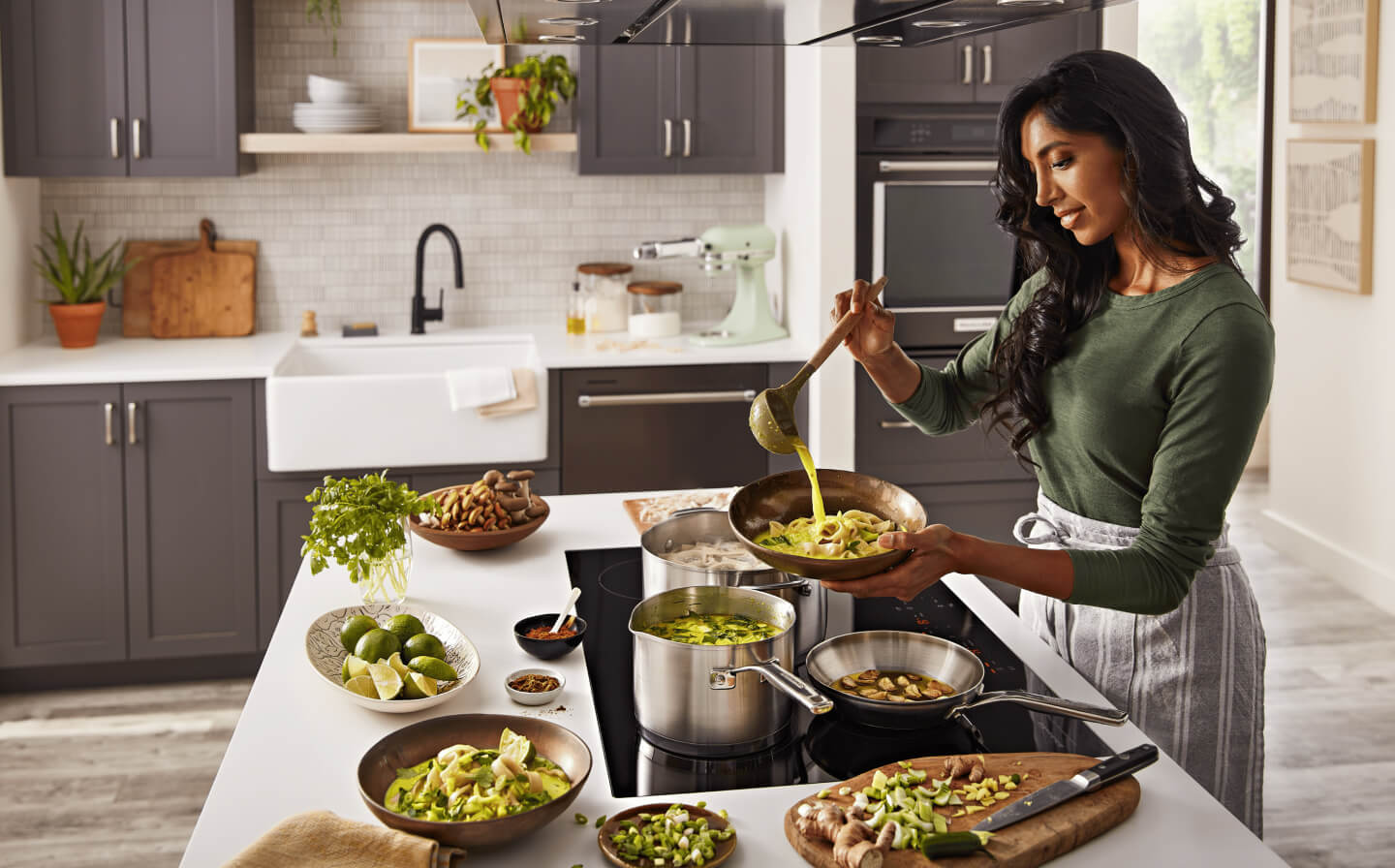 Person cooking on a KitchenAid® induction cooktop