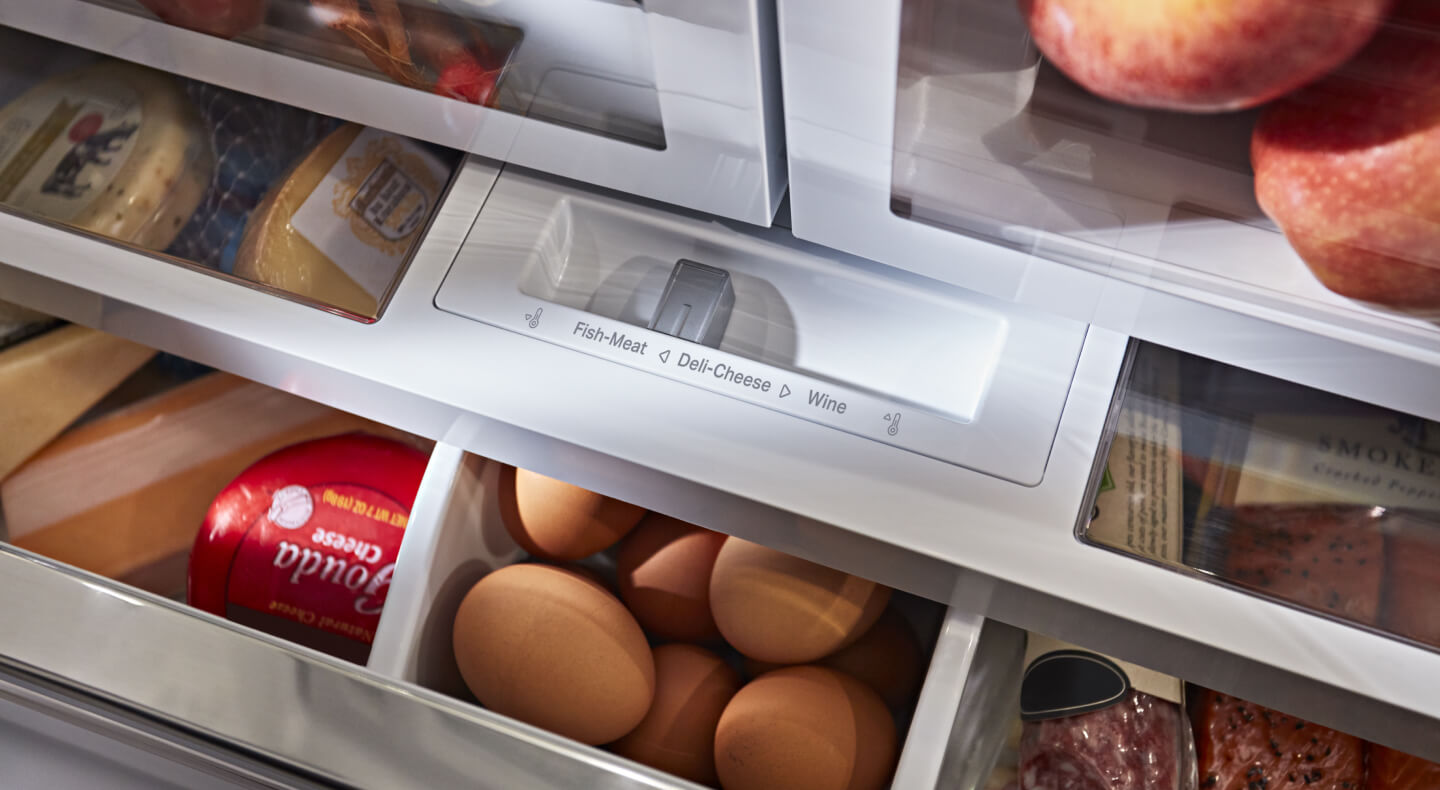  A closeup of refrigerator drawers with eggs and cheese in them