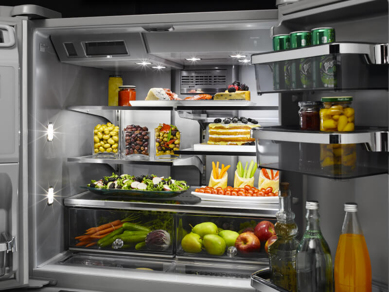 A closeup of a very organized refrigerator with savory items, such as olives, in it