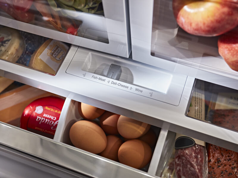  A closeup of refrigerator drawers with eggs and cheese in them