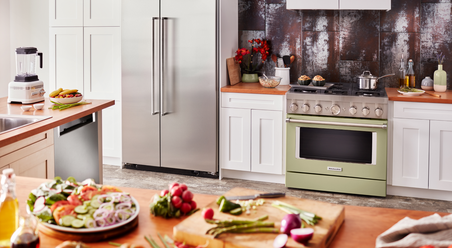 Olive green KitchenAid® gas range in white cabinetry with a rustic backsplash Olive green KitchenAid® gas range in white cabinetry with a rustic backsplash