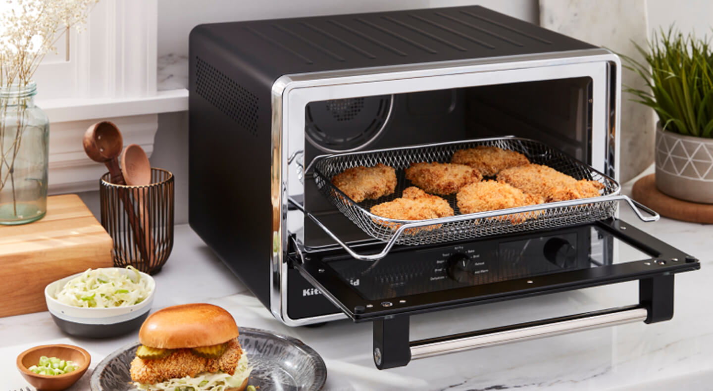 A KitchenAid® countertop oven preparing chicken patties for sandwiches A KitchenAid® countertop oven preparing chicken patties for sandwiches