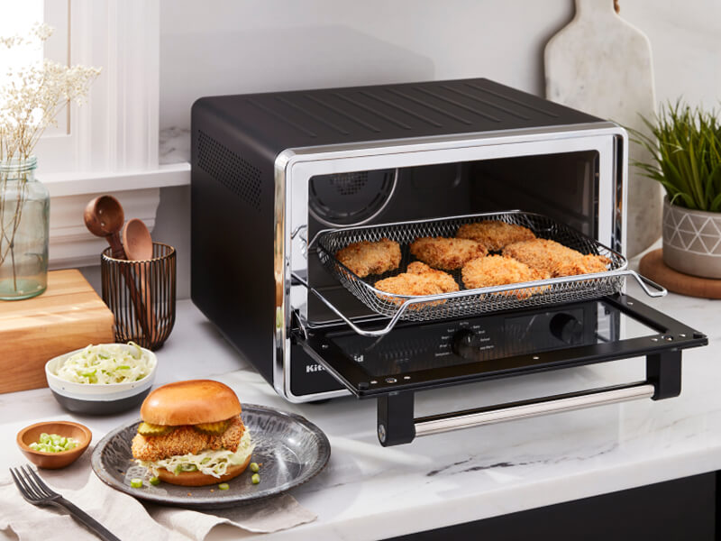 A KitchenAid® countertop oven preparing chicken patties for sandwiches A KitchenAid® countertop oven preparing chicken patties for sandwiches