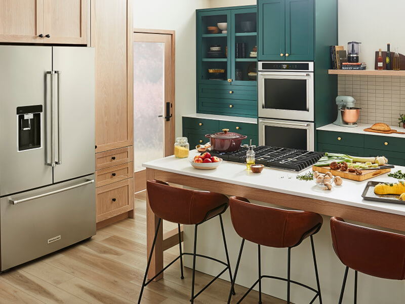 A trendy kitchen with teal cabinetry and a suite of KitchenAid® appliances A trendy kitchen with teal cabinetry and a suite of KitchenAid® appliances