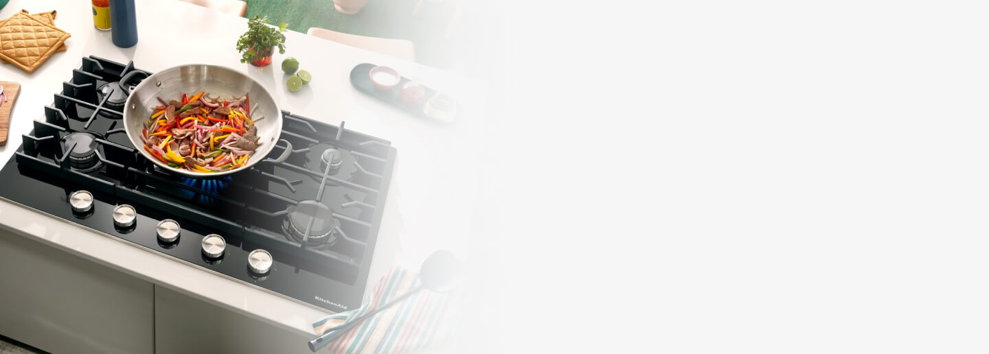 Vegetables cooking in a wok on a gas cooktop