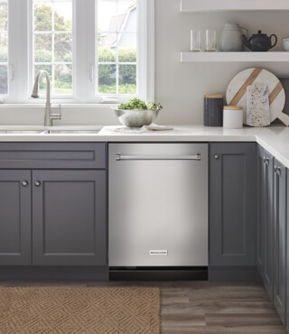 A KitchenAid® dishwasher installed in gray cabinetry